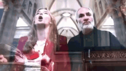 a man and a woman are standing in a church .