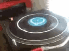 a close up of a spinning record player with a blue light coming out of the center .