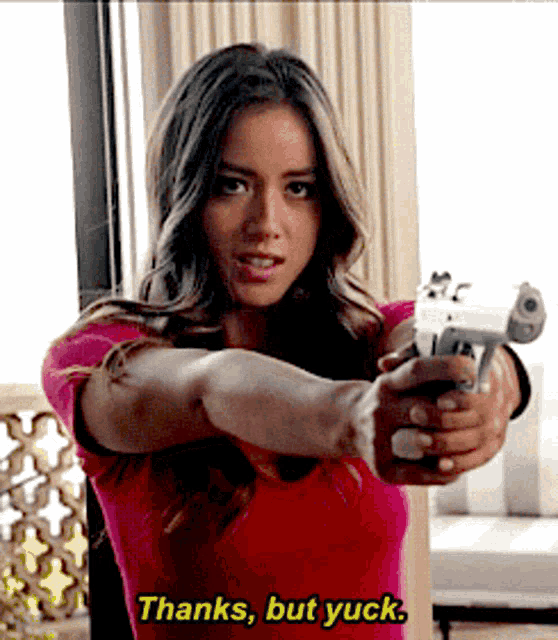 a woman in a red shirt is pointing a gun at the camera and says thanks but yuck