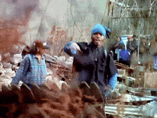 a man wearing a blue beanie is standing in a pile of dirt