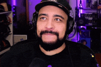 a man with a beard wearing headphones and a baseball cap