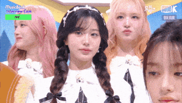 a group of girls are standing in front of a screen that says " musicbank interview cam "