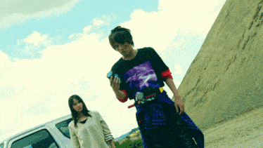 a man and a woman are standing next to a car