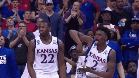 two kansas basketball players are standing in front of the crowd