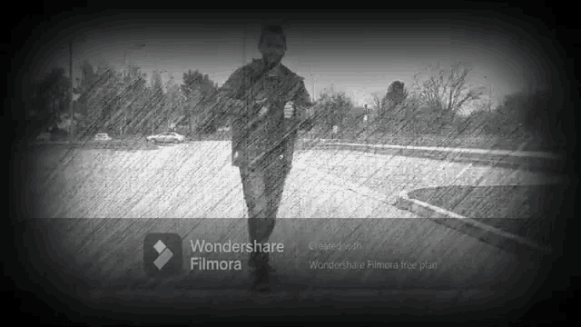 a black and white photo of a man walking with wondershare filmora written on the bottom