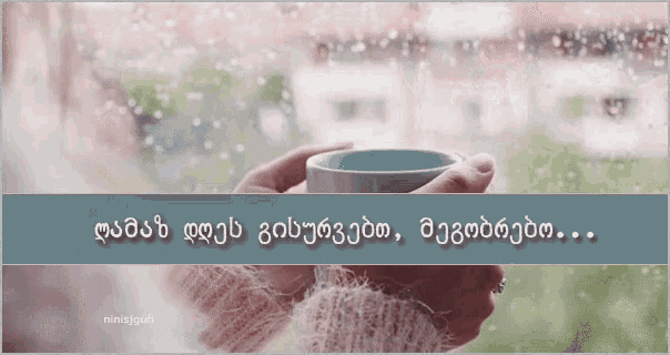 a person holding a cup of coffee in front of a window with foreign writing on it