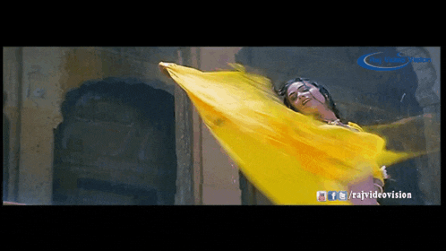 a woman in a yellow dress is dancing in the rain with a watermark for raj video vision