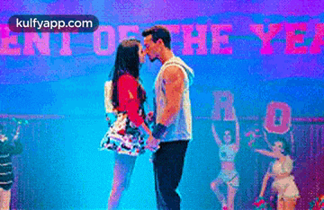 a man and a woman are dancing on a stage in front of a sign that says ent of the year .