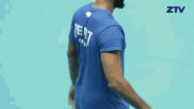 a man wearing a blue shirt that says ztv on the back