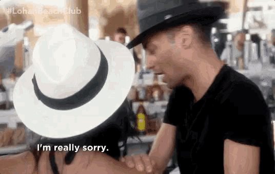 a man wearing a hat says i 'm really sorry to a woman