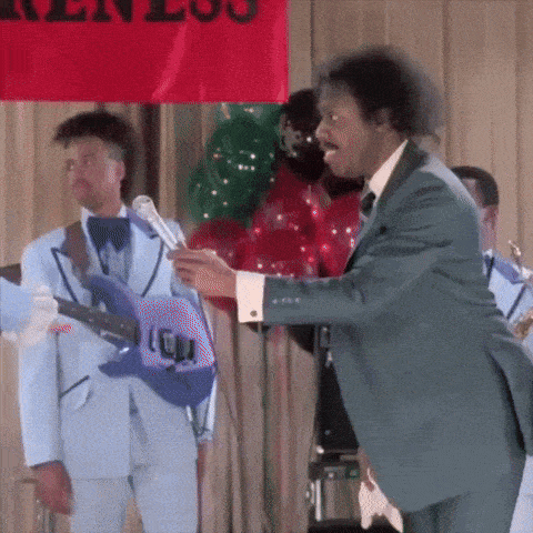 a man in a suit is holding a guitar in front of a sign that says ' ken lou ' on it