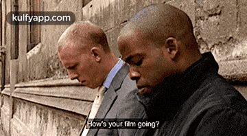 two men are sitting next to each other and one is asking the other how 's your film going .