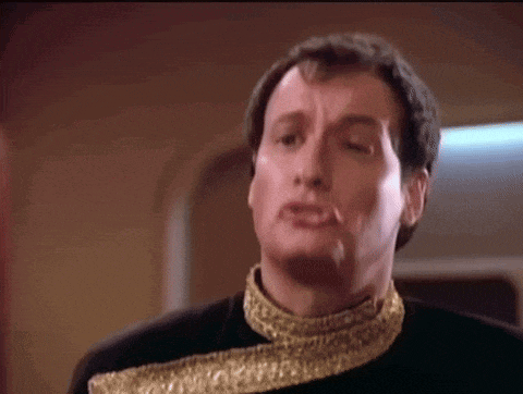 a man in a black and gold outfit is making a face
