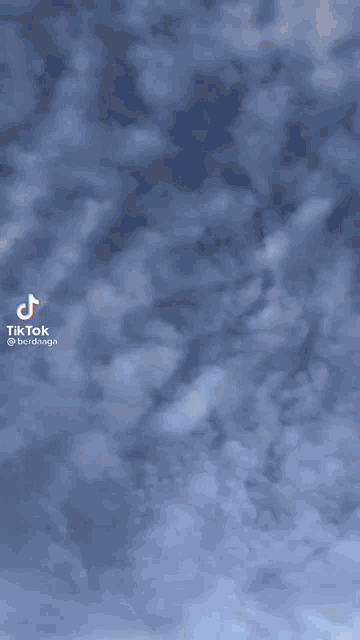 a blue sky with clouds and a tiktok logo