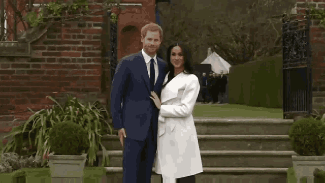 a man in a suit and tie and a woman in a white coat are standing next to each other .