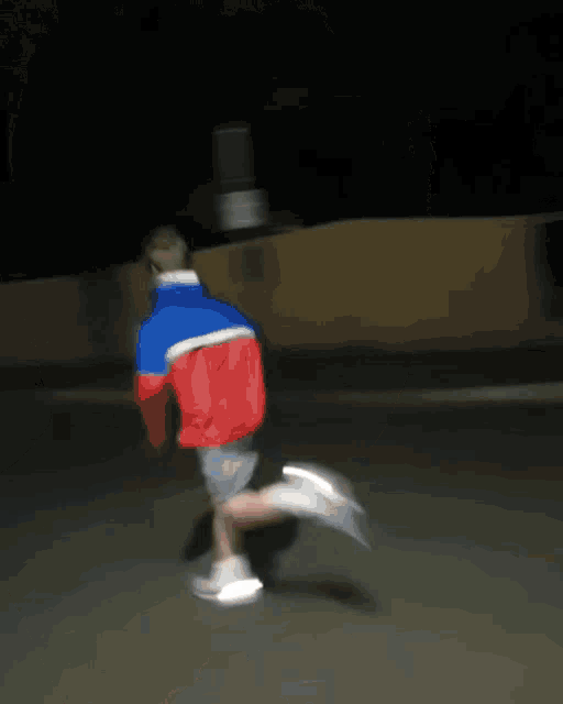 a blurry picture of a person walking down a street at night