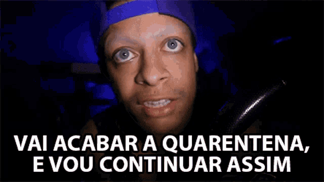 a man wearing a purple hat is looking at the camera with the words vai acabar a quarentena e vou continuar assim below him