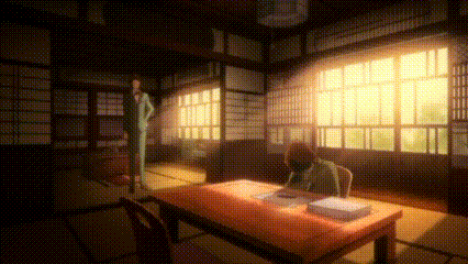a man in a suit is standing next to a table in a room .