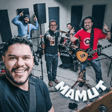 a group of men standing in front of a drum set with the word mamuk on the bottom