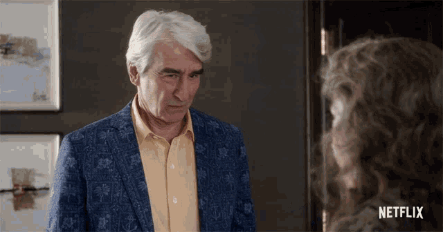 a man in a blue jacket and a yellow shirt is talking to a woman in a netflix ad