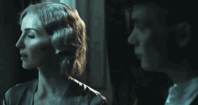 a man and a woman are looking up at something in the dark