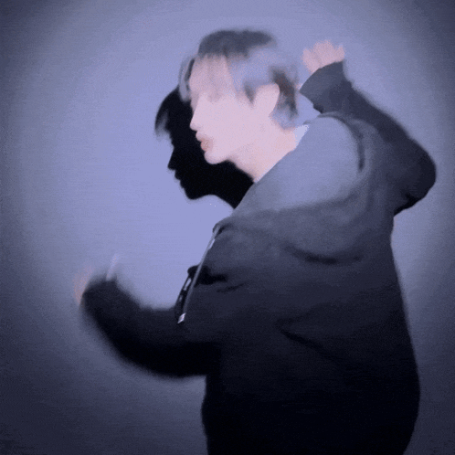 a blurry picture of a man in a black jacket dancing