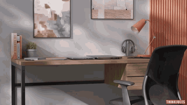 a desk with a laptop and headphones on it with a think jules logo in the corner