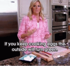 a woman in a pink shirt is standing in a kitchen