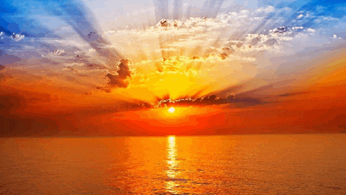 the sun is setting over the ocean and the sun is shining through the clouds