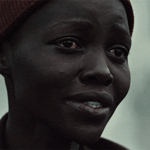 a close up of a person 's face with a tear coming out of her eye