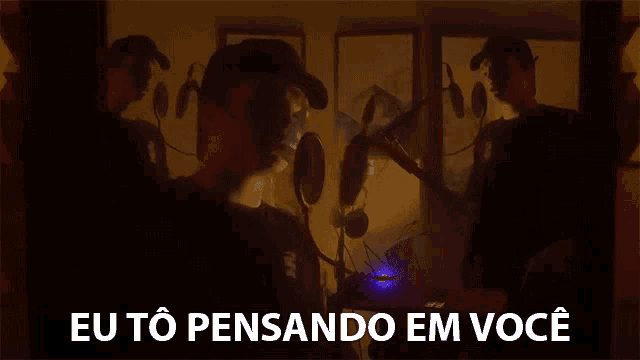 a man singing into a microphone with the words " eu to pensando em você " above him