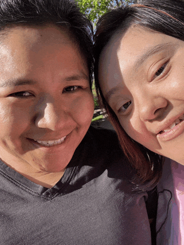 a woman and a girl are posing for a picture and smiling for the camera