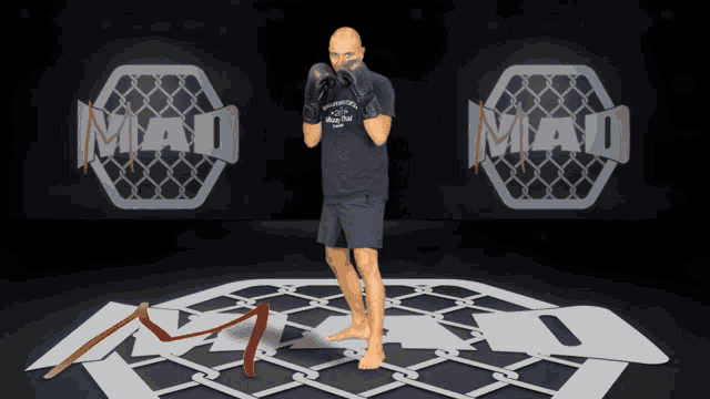 a man wearing boxing gloves is standing in front of a sign that says mad