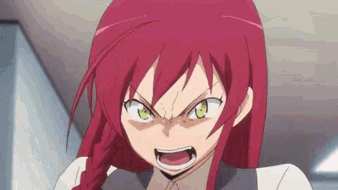 a close up of a girl with red hair and green eyes making a funny face .