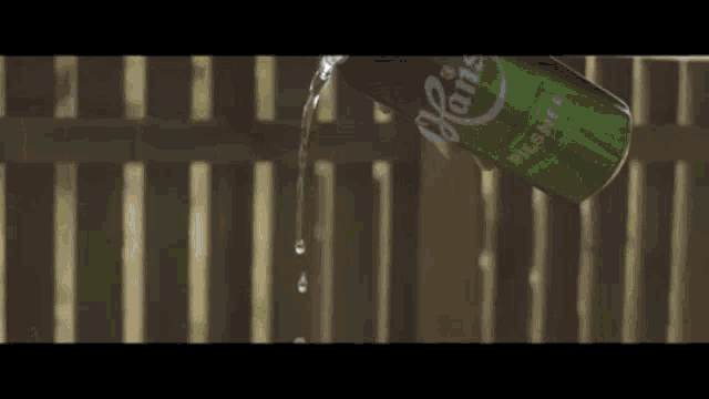 a can of pilsner beer is being poured into a fence
