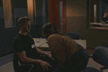 a man and a woman sit at a desk with a laptop on it