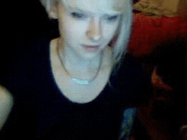 a close up of a woman 's face with a necklace around her neck