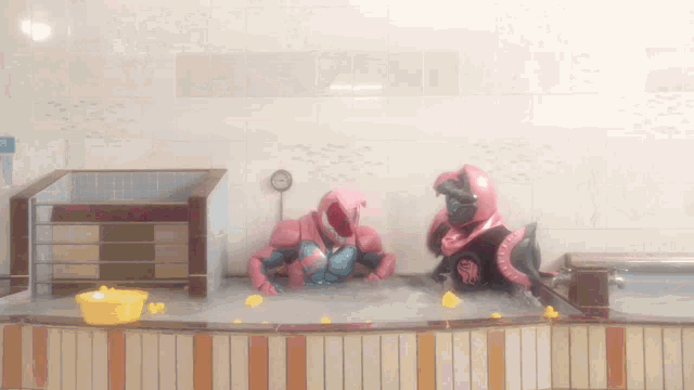 two robots are playing in a bathtub with yellow rubber toys