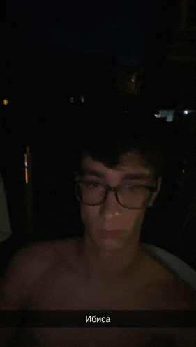 a man without a shirt is wearing glasses and has the word " ibisa " on the bottom right