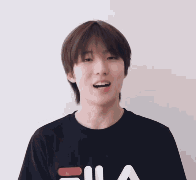a young man wearing a black fila t-shirt
