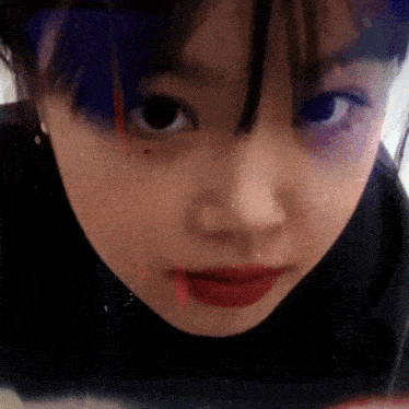 a close up of a woman 's face with a red lip