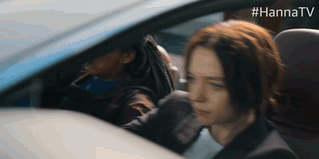 a woman is sitting in a car with #hannatv written on the bottom