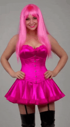 a woman with pink hair is wearing a pink corset and black thigh high boots .