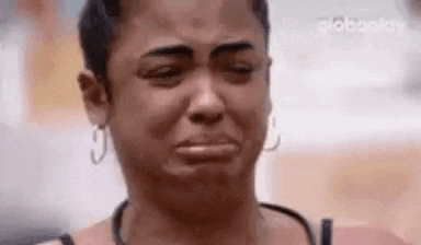 a woman is crying with her eyes closed and a tear running down her face .
