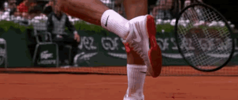a tennis player wearing nike socks is holding a tennis racquet on a court