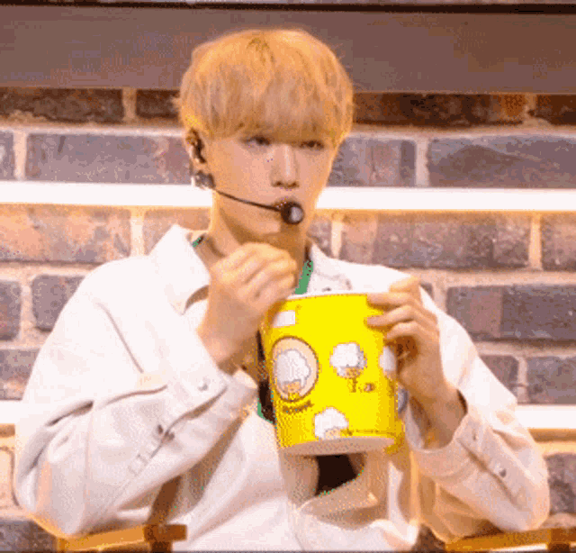 a man wearing a headset is holding a yellow cup with a chef on it