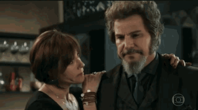 a man with a beard and a woman are hugging