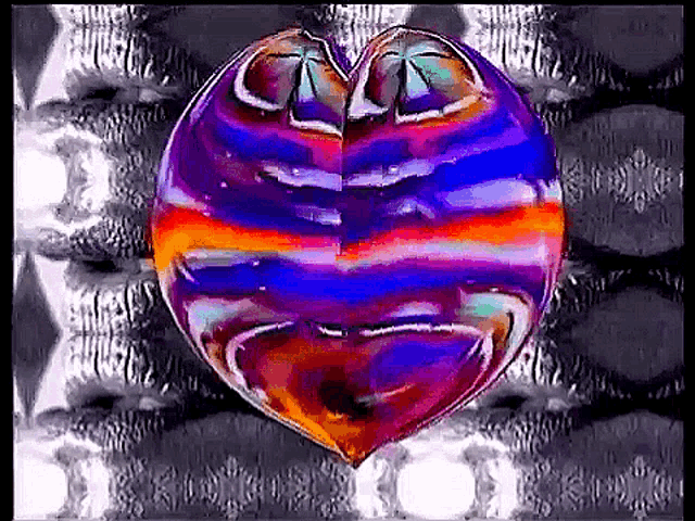 a colorful heart shaped object is floating in the air on a black and white background