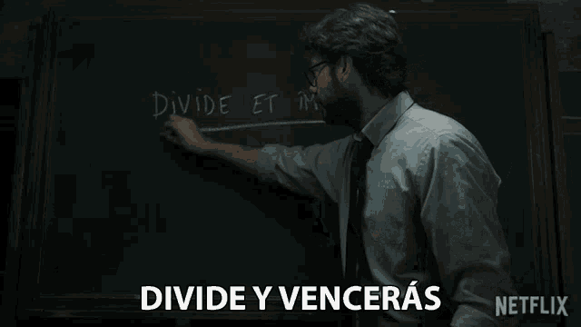 a man writing on a blackboard with the words divide et impe written on it