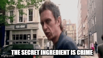 a man is standing on a city street with the words `` the secret ingredient is crime '' written on his face .